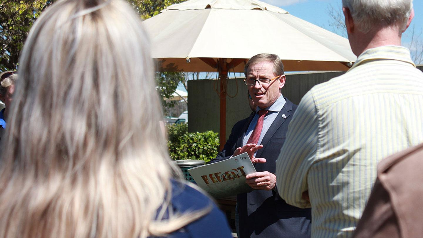 KBR Government Solutions APAC VP Rob Hawketts holding copy of KBR's Reconciliation Action Plan