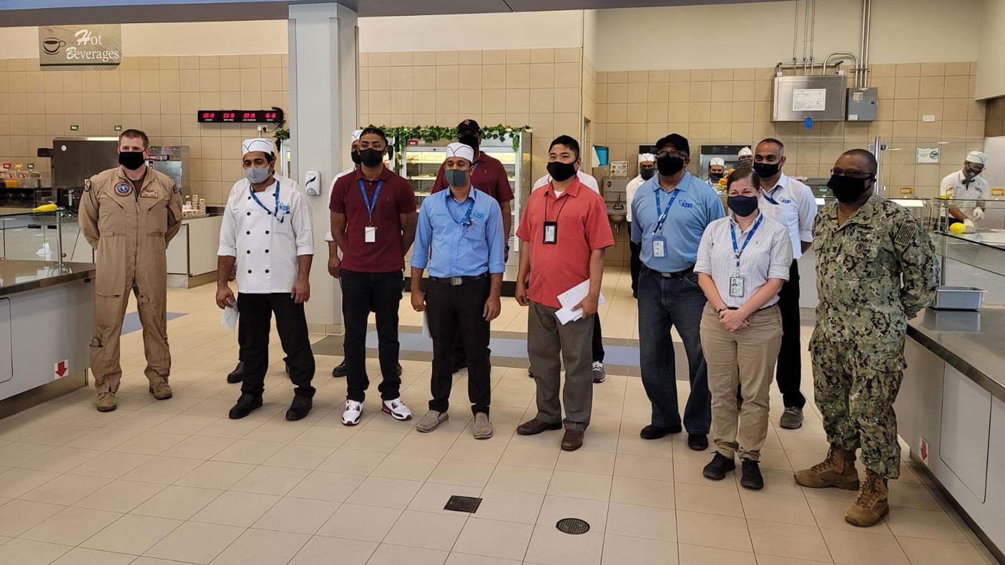 Naval Activity Support (NSA) military leadership Captain Smith (far left) recognize KBR’s NSA galley manager, Alberto Estrada (fourth from right) and team in Bahrain.